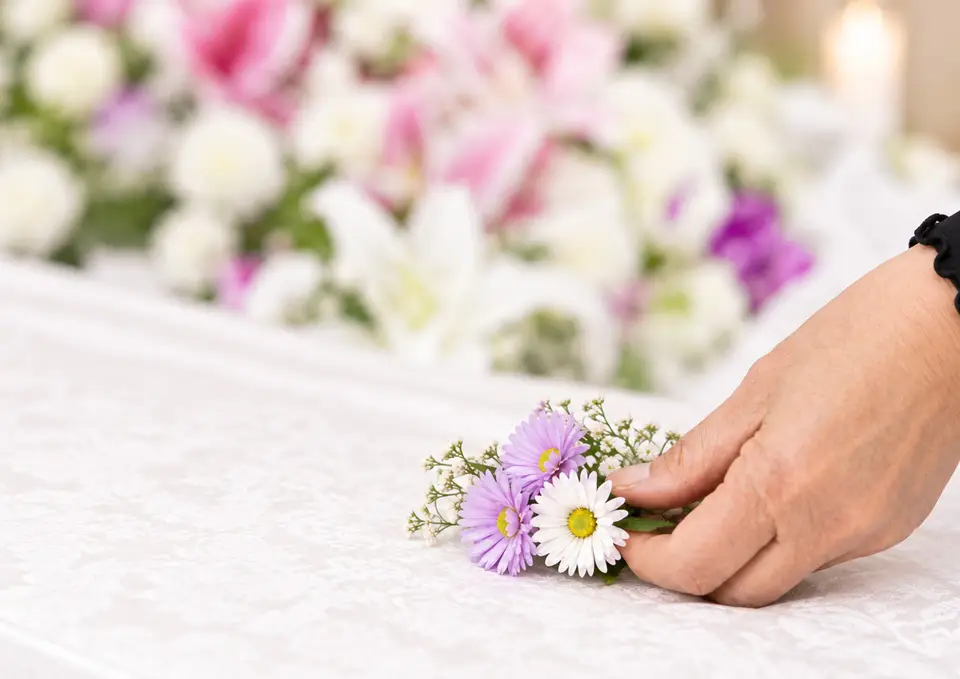 江東区葬儀社アスターが行うお葬式の棺に、アスターのお花をそっと添える様子